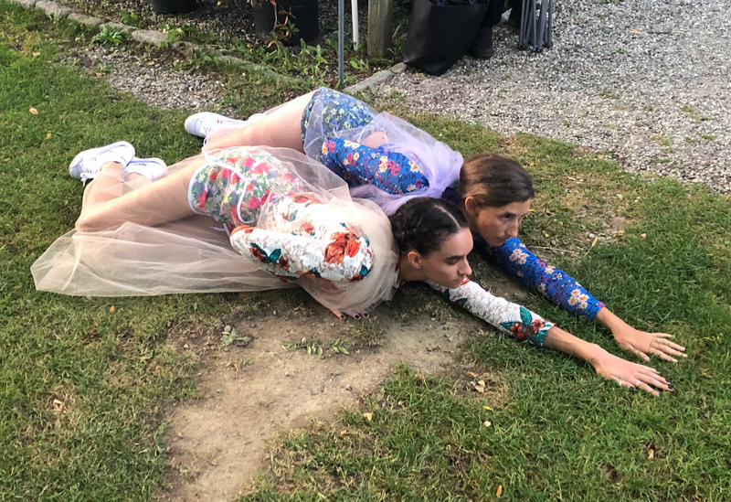 2 women sliding on grass