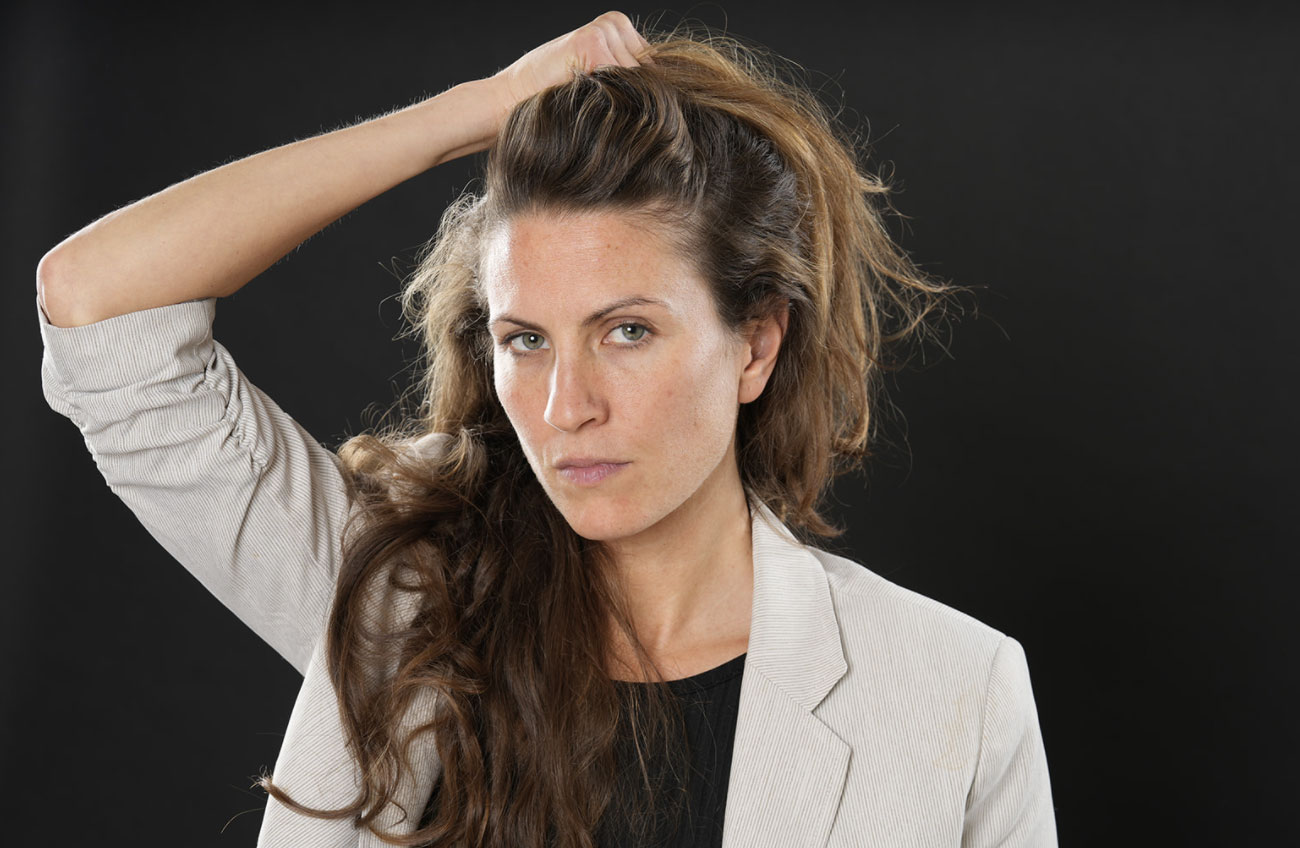 woman holding up her hair while looking intently